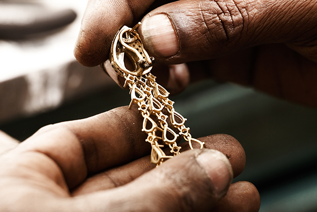 Testing gold jewelry authenticity with a magnet and loupe